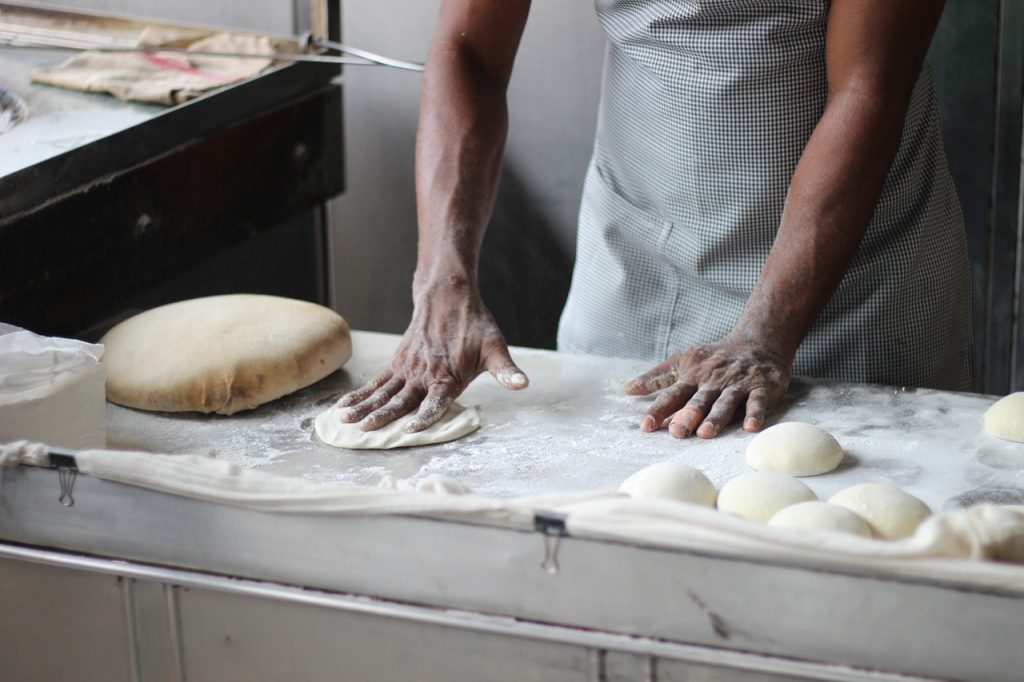 personne qui pétrit une pâte à tarte